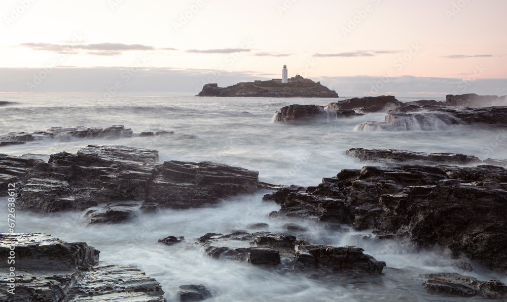 Sunset photograph of the rocky shores near the lighthouse at Godrevy, Cornwall.