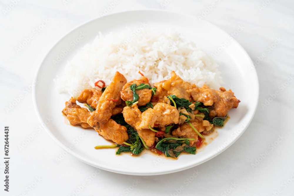 stir-fried fried fish with basil and chili in thai style topped on rice stir-fried fried fish with basil and chili in thai style topped on rice