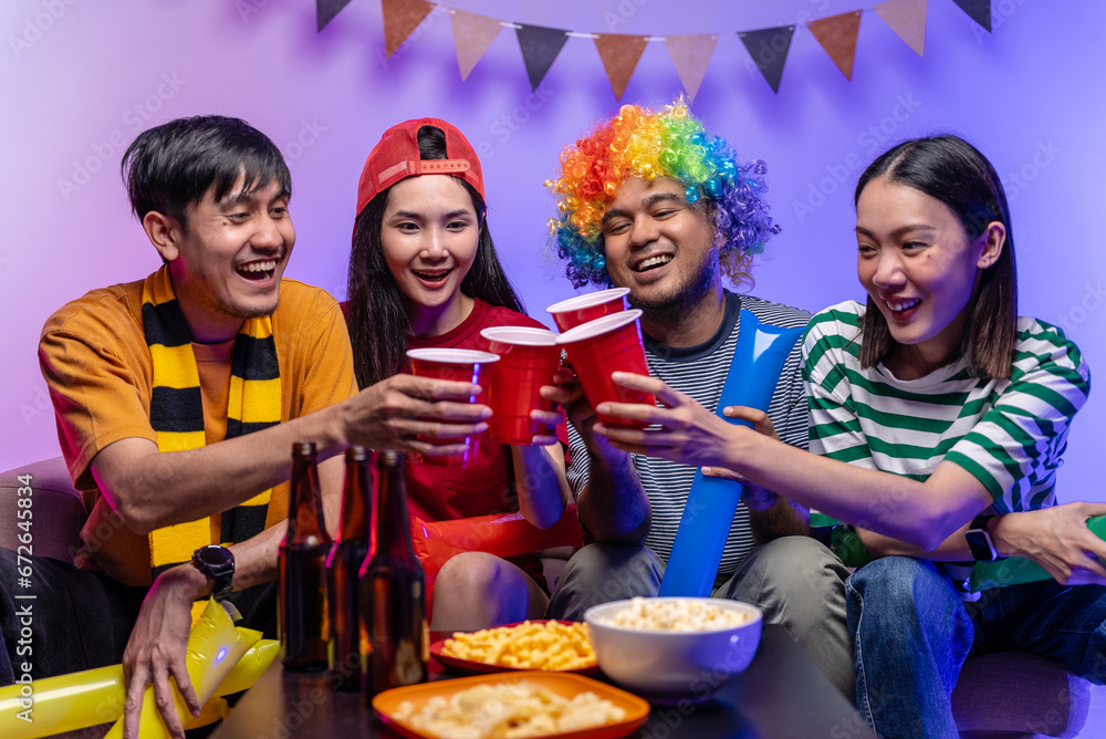 Happy asian diverse group friends watching soccer games world cup competition on television with drinking beer at home. Sport fans people shouting and celebrating sport team victory match. Happy asian diverse group friends watching soccer games world cup competition on television with drinking beer at home. Sport fans people shouting and celebrating sport team victory match.
