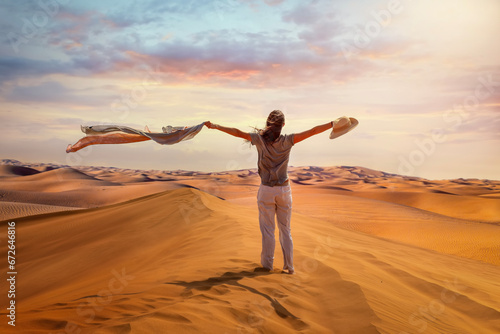 Photography A tourist woman stands in the Red Desert of Dubai waving her scarf in the hot ai