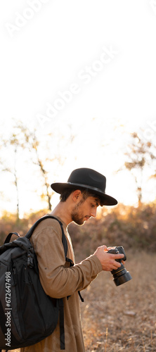 Travel photographer taking nature photo or video of mountain landscape at autumn. Hiker tourist professional videographer on adventure vacation shooting on dslr camera
