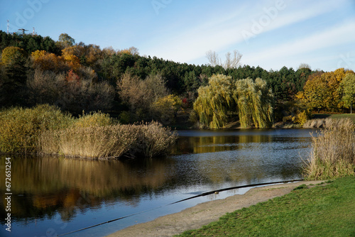 Lake in park in fall with trees reflecting in water photo