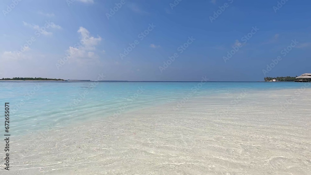 Maldives beach, waves wash the shore with white sand, clear azure water, and blue sky. Beauty, paradise, Indian ocean view Maldives beach, waves wash the shore with white sand, clear azure water, and blue sky. Beauty, paradise, Indian ocean view
