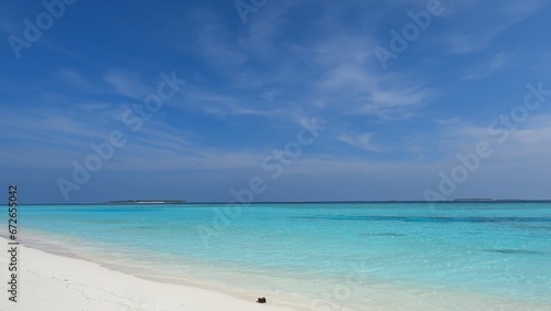 Fototapeta Naklejka Na Ścianę i Meble -  Maldives beach, waves wash the shore with white sand, clear azure water, and blue sky. Beauty, paradise, Indian ocean view