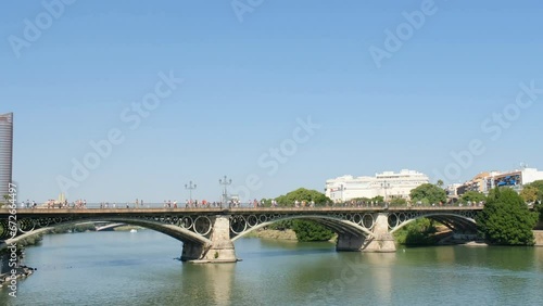 Panoramic view of famous Triana river bridge with perople and traffic in Seville city, European Spanish landmark photo