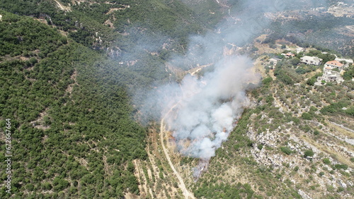 Fire on a mountain with smoke in a sunny day. Natural disaster