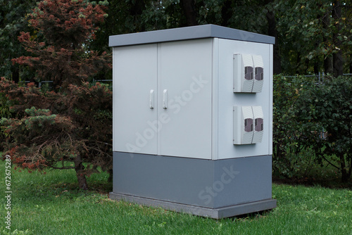 Technical equipment cabinet, outdoor electrical equipment box on the grass in the park.