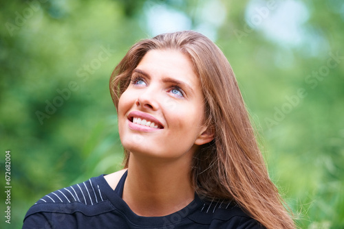 Park, happy woman or thinking outdoors to relax on a holiday vacation in summer or nature. Face, looking up or thoughtful female person on break for ideas or mindfulness for scenic travel in forest