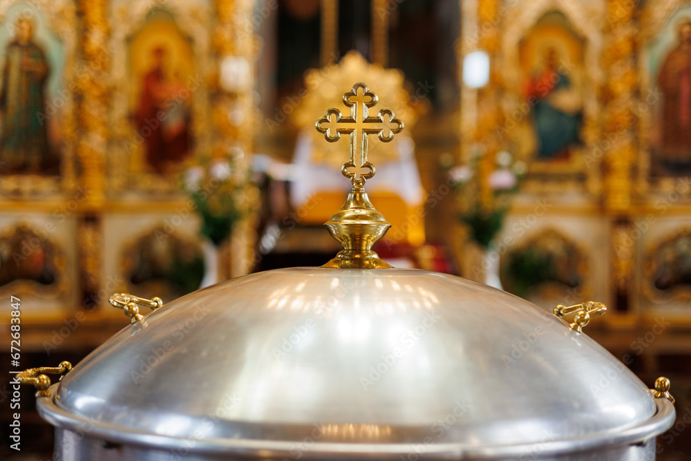 Aluminium church font, large bowl, with golden cross and saint water for the baptism of babies in Orthodox Church temple, Christening ceremony.Concept of rituals, sacraments of the Christian religion. - obrazy, fototapety, plakaty 