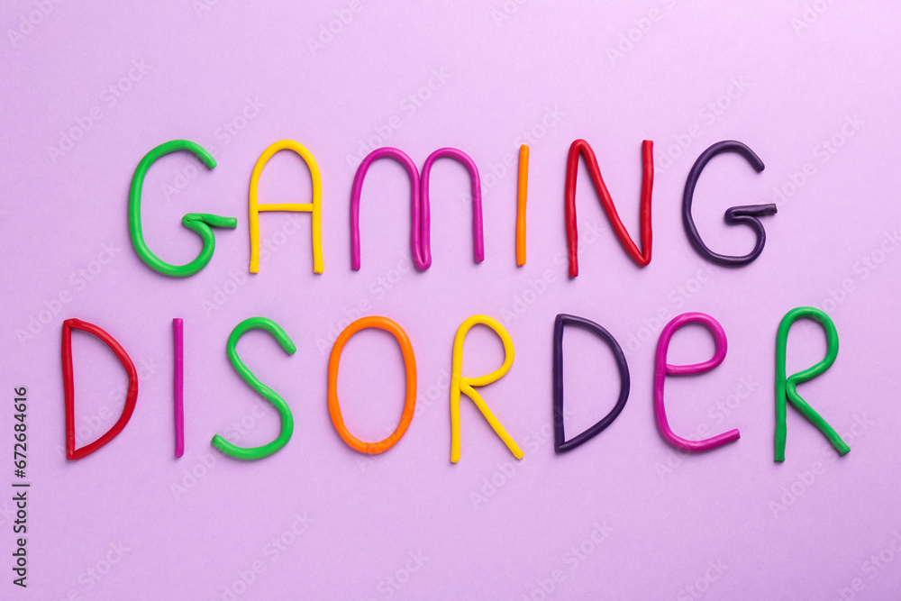 Phrase Gaming Disorder made of colorful plasticine on violet background, top view