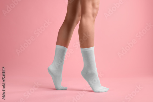 Woman in stylish white socks on pink background, closeup