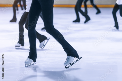 Female skaters practice on the ice in a group of the figure skating sports section. Girls' legs. Selective focus.