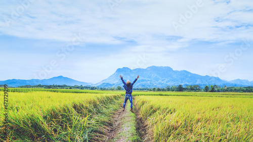 Asian man travel relax in the holiday. Jump natural touch mountain field. Jump stand glad middle field rice. Thailand