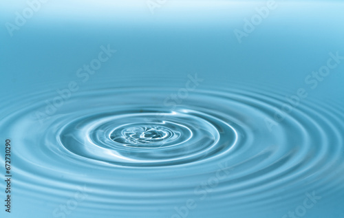 A blue concentric water wave splashing in close-up motion.