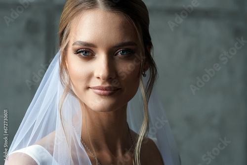 The bride in a white dress with a veil. Portrait of a girl in a wedding dress.