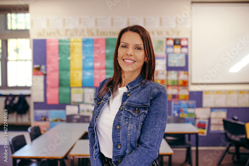 Happy primary school teacher in classroom smiling at camera photo