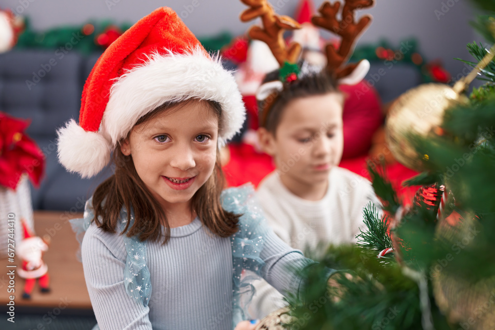 Adorable boy and girl decorating christmas tree at home Adorable boy and girl decorating christmas tree at home