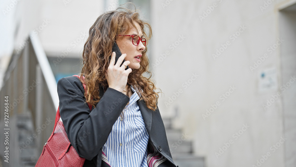 Fototapeta premium Young woman business worker talking on smartphone at street