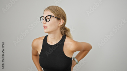Young blonde woman suffering for backache over isolated white background