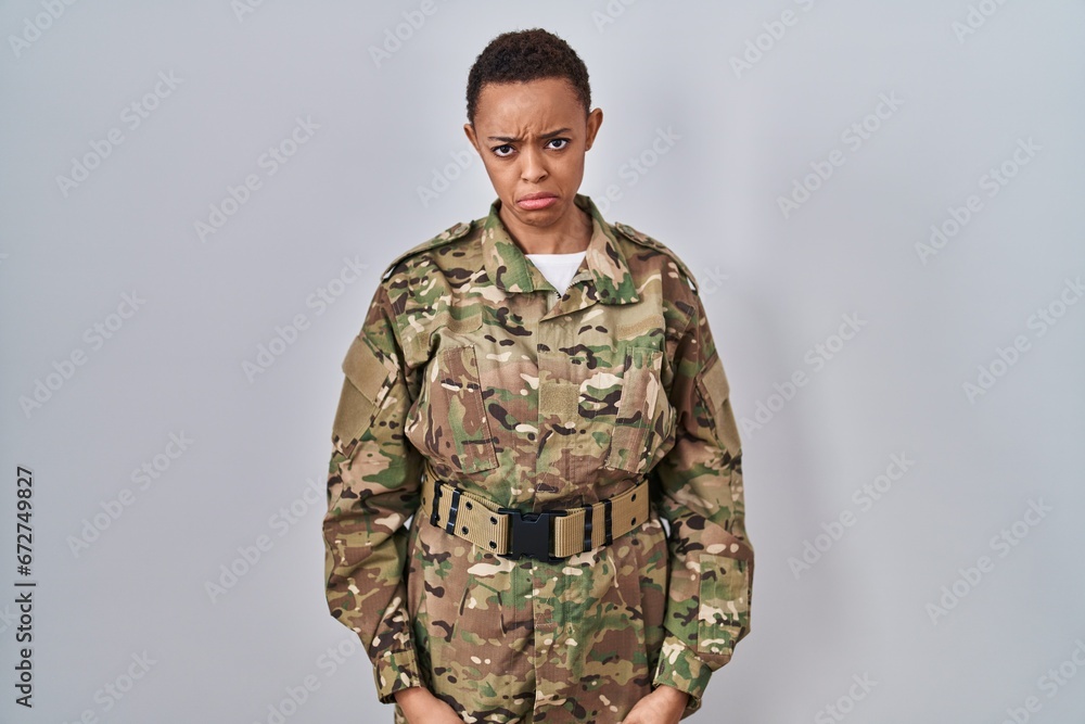 Beautiful african american woman wearing camouflage army uniform depressed and worry for distress, crying angry and afraid. sad expression.