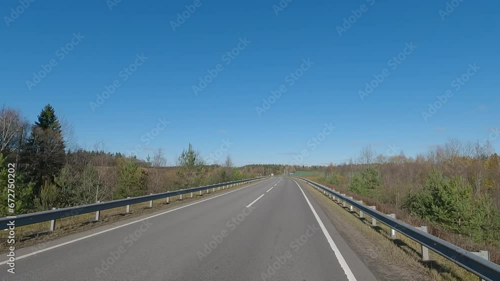 The car drives along the road on a autumn day. Highways, roadside and road line markings. The car drives along the road on a autumn day. Highways, roadside and road line markings.