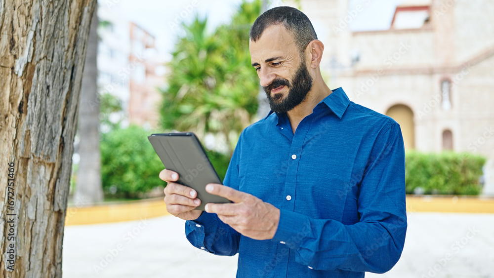 Young hispanic man smiling confident using touchpad at park Young hispanic man smiling confident using touchpad at park