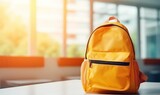 school backpack on a table in classroom on sunny morning