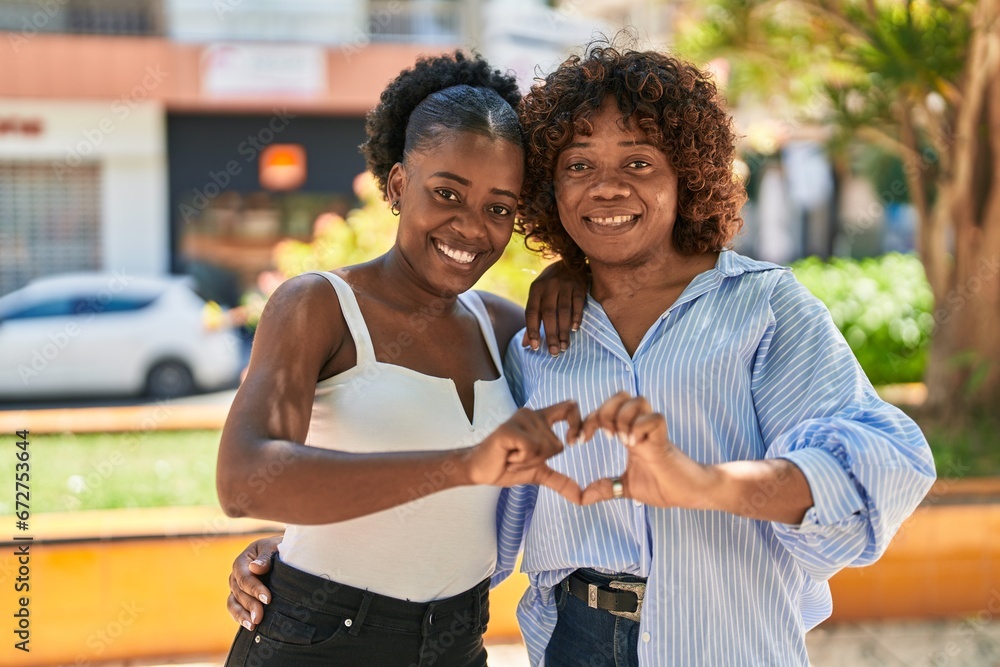 African american women mother and daughter doing heart gesture with hands at park - obrazy, fototapety, plakaty 