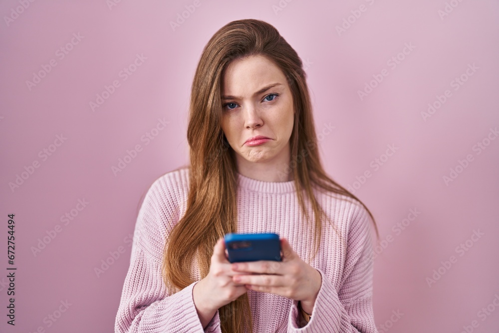 Young caucasian woman using smartphone typing message depressed and worry for distress, crying angry and afraid. sad expression. Young caucasian woman using smartphone typing message depressed and worry for distress, crying angry and afraid. sad expression.