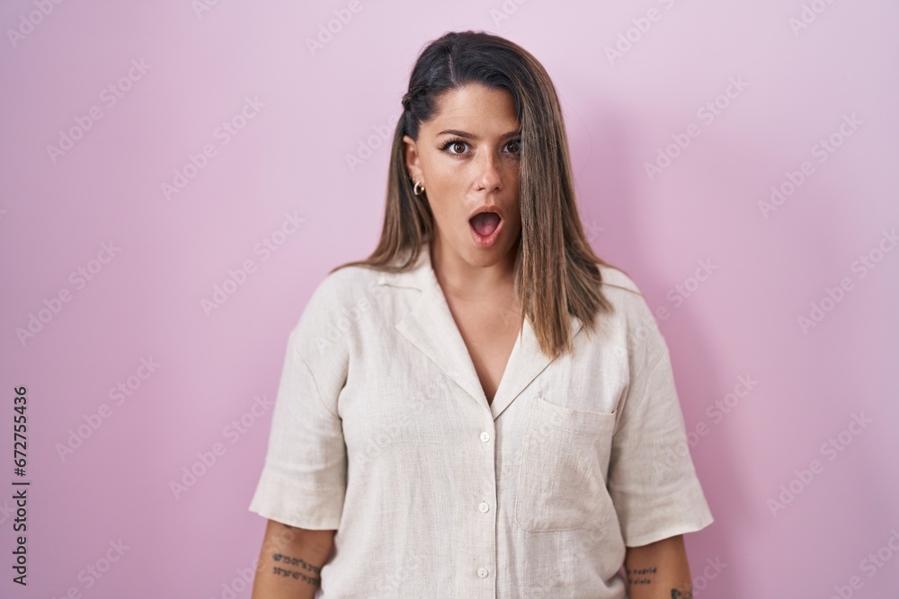 Blonde woman standing over pink background in shock face, looking skeptical and sarcastic, surprised with open mouth Blonde woman standing over pink background in shock face, looking skeptical and sarcastic, surprised with open mouth
