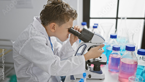 Adorable little blond boy scientist, engrossed in serious research, meticulously working at a microscope in a professional lab, zooming in for a deeper analysis