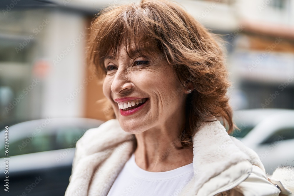 Middle age woman smiling confident looking to the side at street
