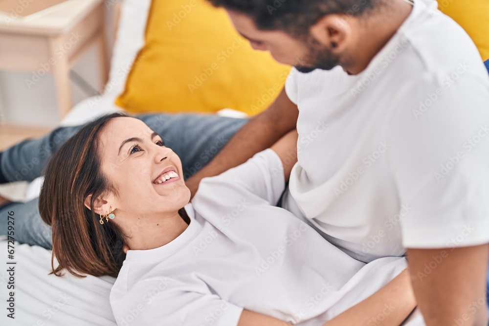 Fototapeta premium Man and woman couple smiling confident lying on bed at bedroom