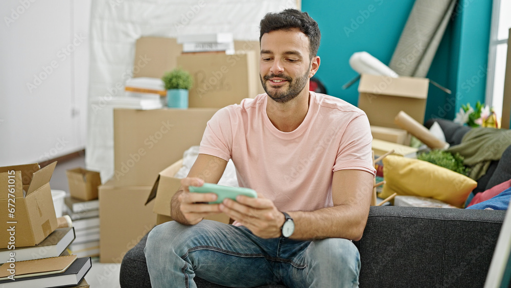Young hispanic man playing video game looking upset at new home Young hispanic man playing video game looking upset at new home
