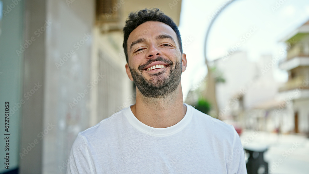 Obraz premium Young hispanic man smiling confident standing at street