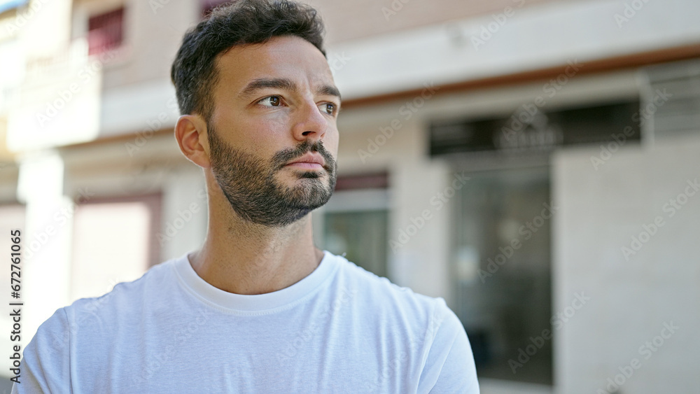 Obraz premium Young hispanic man looking to the side with serious expression at street