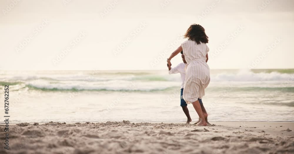 Family, beach and a mother dancing with her son on the sand together by the ocean or sea at sunset. Energy, freedom and a black woman having fun with her boy child in nature on holiday or vacation Family, beach and a mother dancing with her son on the sand together by the ocean or sea at sunset. Energy, freedom and a black woman having fun with her boy child in nature on holiday or vacation