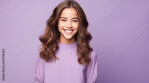 Happy teen girl  smiling and laughing  wearing a solid bright lavender dress. solid bright lavender background similar to the dress color.