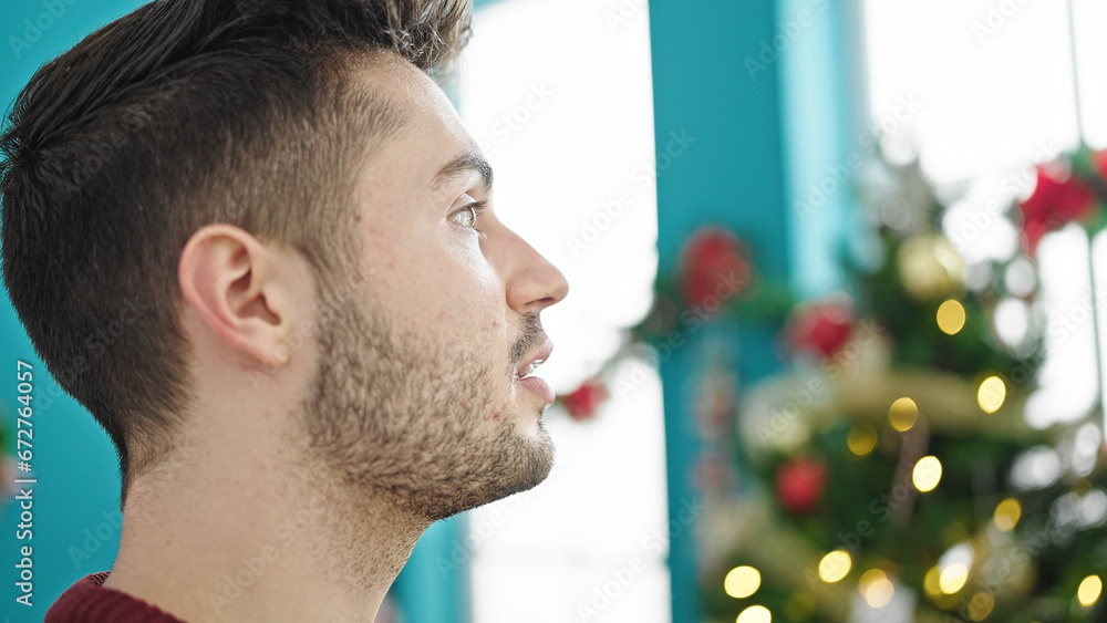 Obraz premium Young hispanic man celebrating christmas with serious face at home