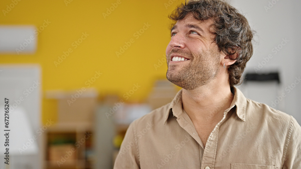 Fototapeta premium Young hispanic man smiling confident looking to the side at new home