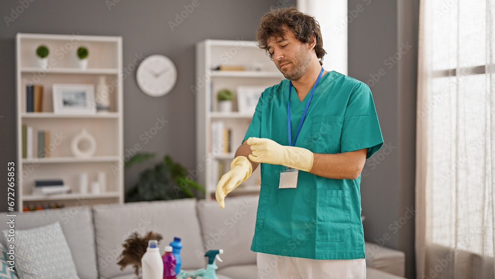 Fototapeta premium Young hispanic man professional cleaner wearing gloves smiling at home