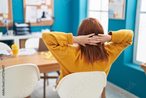 Young beautiful plus size woman business worker relaxed with hands on head at office