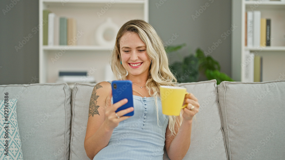 Young blonde woman using smartphone drinking coffee at home Young blonde woman using smartphone drinking coffee at home