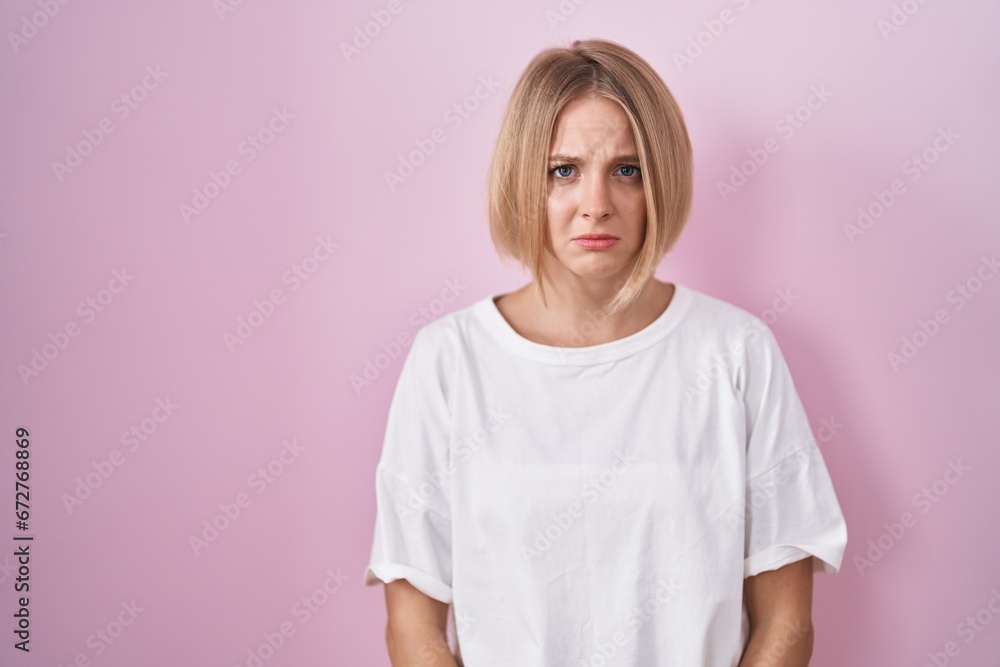 Young caucasian woman standing over pink background depressed and worry for distress, crying angry and afraid. sad expression. Young caucasian woman standing over pink background depressed and worry for distress, crying angry and afraid. sad expression.