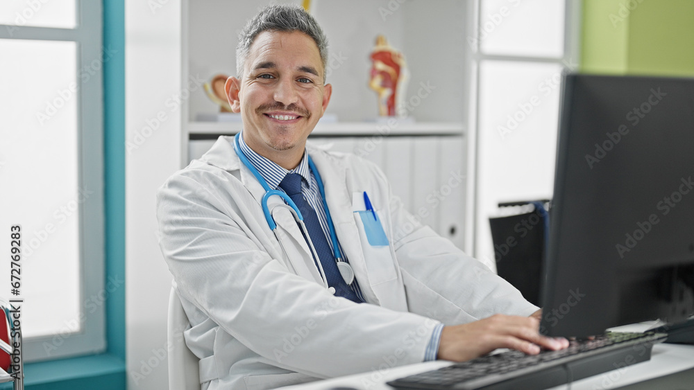 Young hispanic man doctor using computer working at clinic Young hispanic man doctor using computer working at clinic