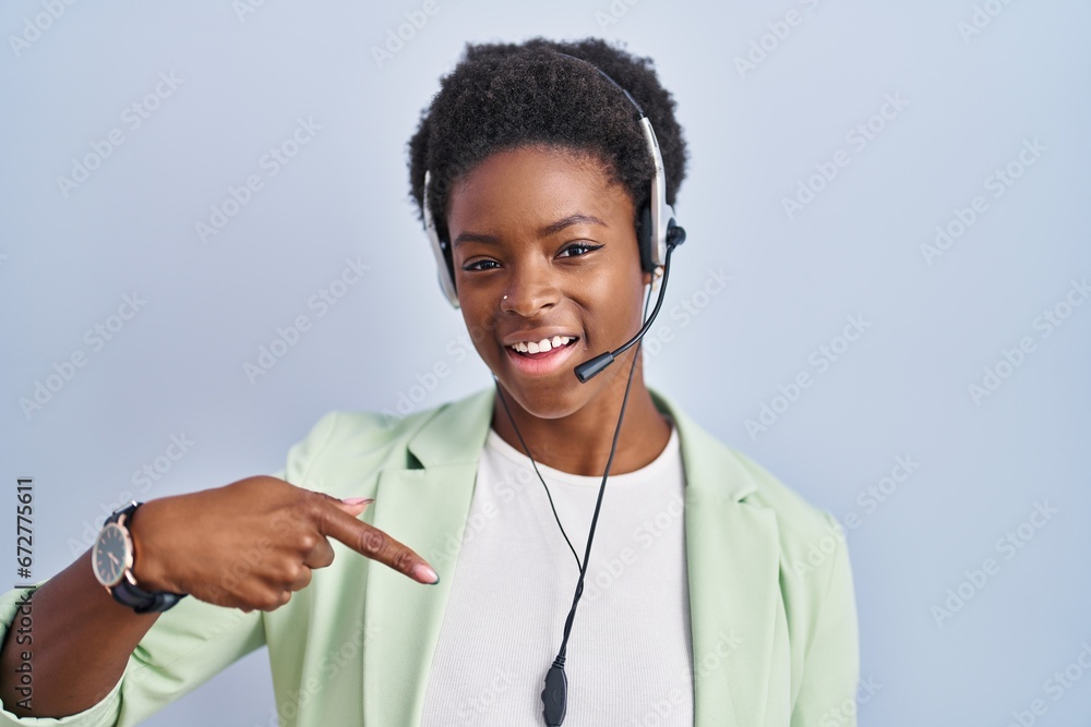 African american woman wearing call center agent headset looking confident with smile on face, pointing oneself with fingers proud and happy. African american woman wearing call center agent headset looking confident with smile on face, pointing oneself with fingers proud and happy.