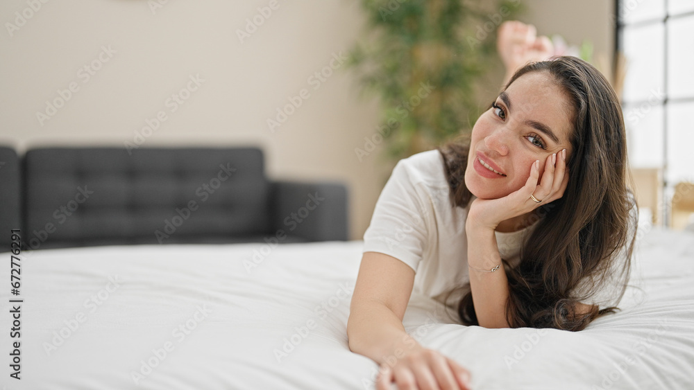 Young beautiful hispanic woman smiling confident lying on bed at bedroom Young beautiful hispanic woman smiling confident lying on bed at bedroom