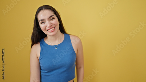 Young beautiful hispanic woman smiling confident standing over isolated yellow background