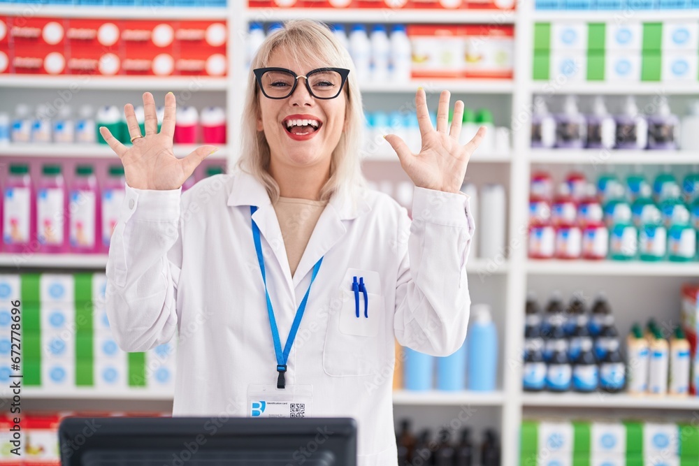 Young caucasian woman working at pharmacy drugstore showing and pointing up with fingers number ten while smiling confident and happy. Young caucasian woman working at pharmacy drugstore showing and pointing up with fingers number ten while smiling confident and happy.