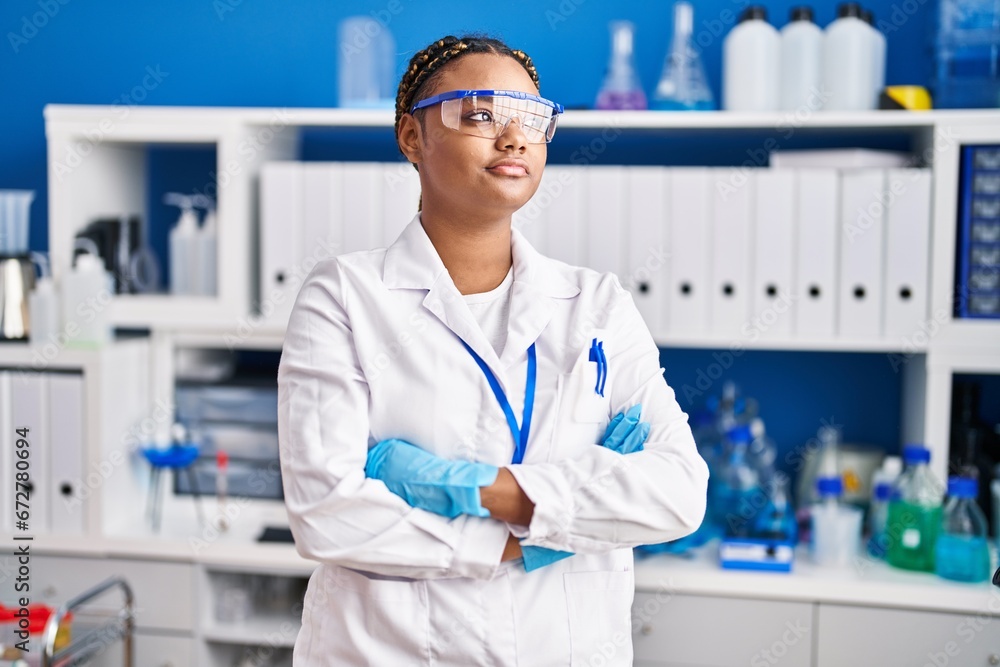 African american woman scientist standing with arms crossed gesture at laboratory African american woman scientist standing with arms crossed gesture at laboratory